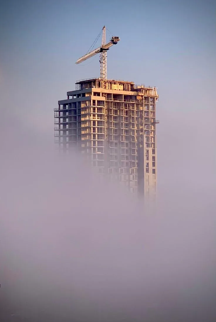 High-rise building under construction with a tower crane